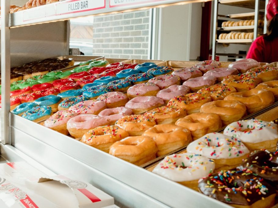 a variety of doughnuts displayed in a case what to buy in june