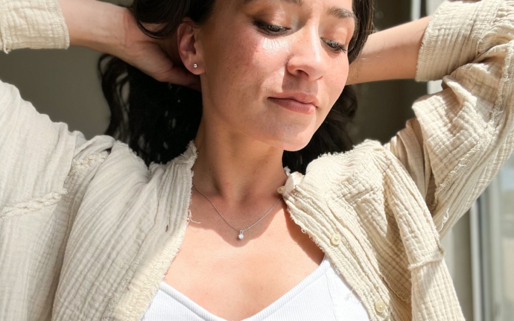 woman with hands behind head in moissanite necklace