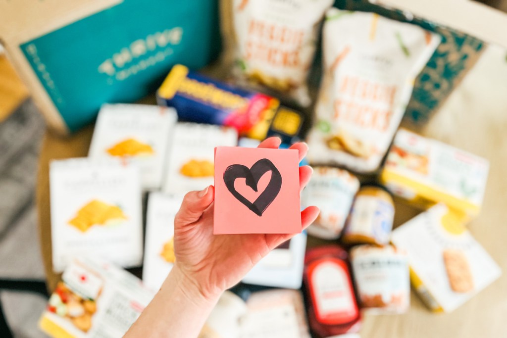 holding heart note over pile of groceries