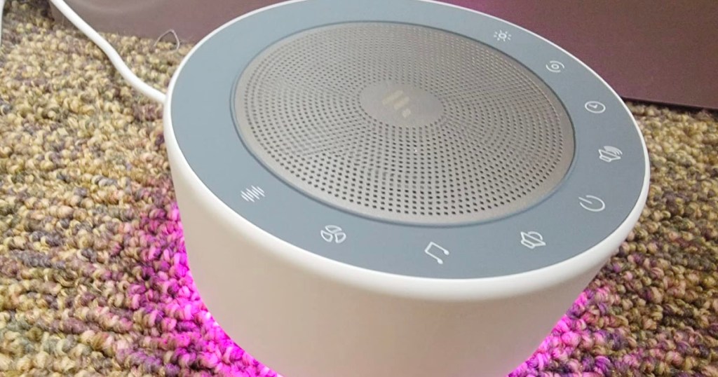 white noise machine sitting on carpet with purple light