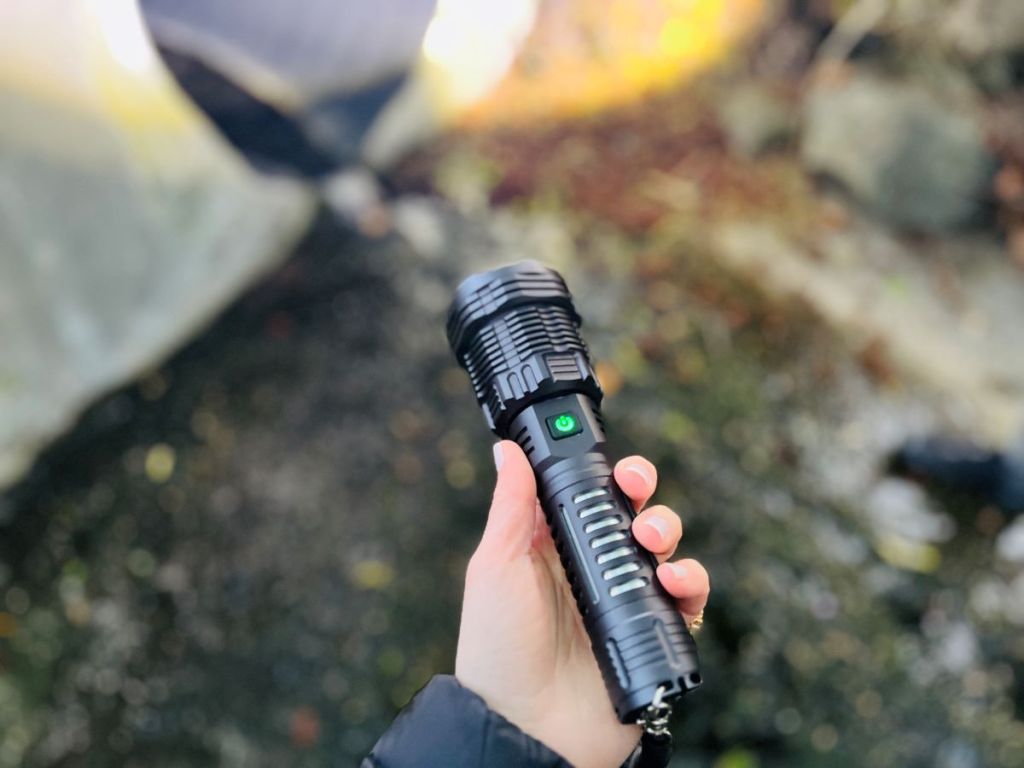 Hand holding a black flashlight