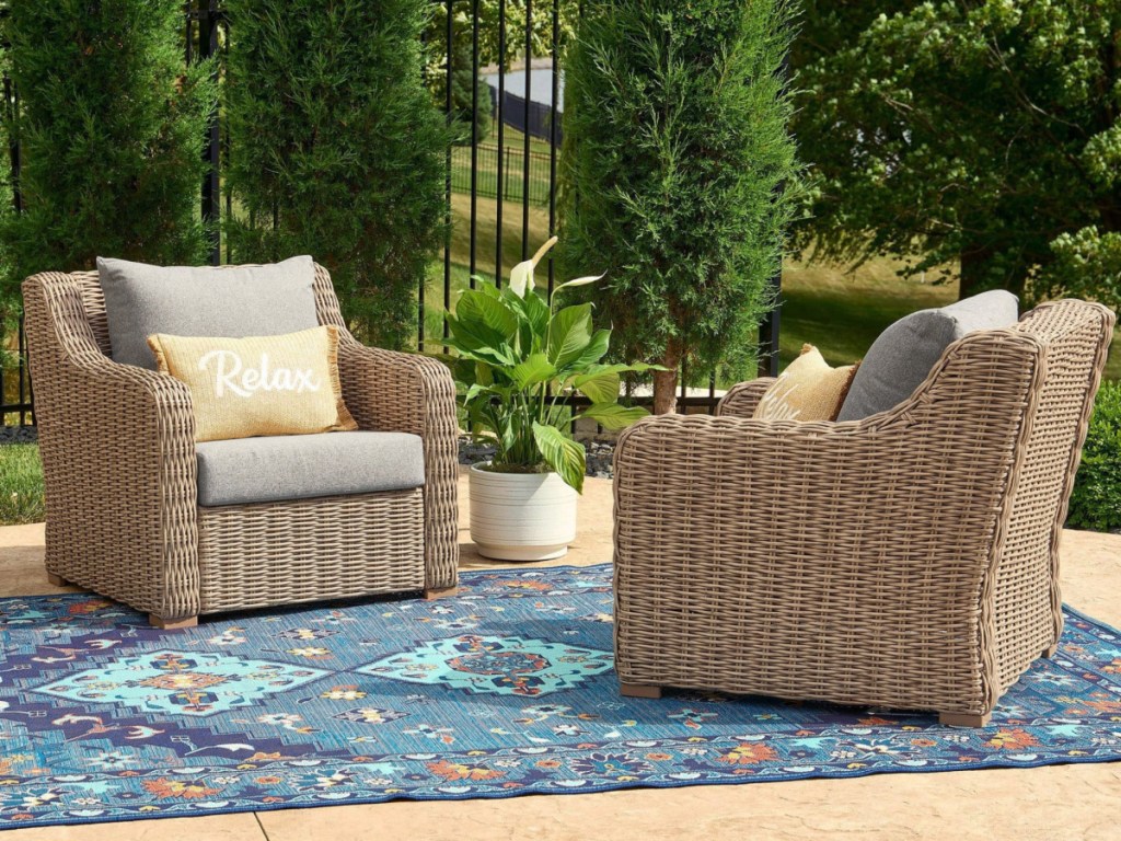 Two wicker Club chairs outside on outdoor rug in backyard