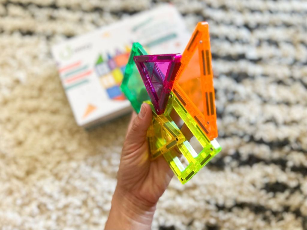 person holding transparent color magnetic blocks