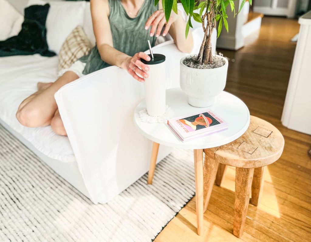 Woman setting her drink on a round side table