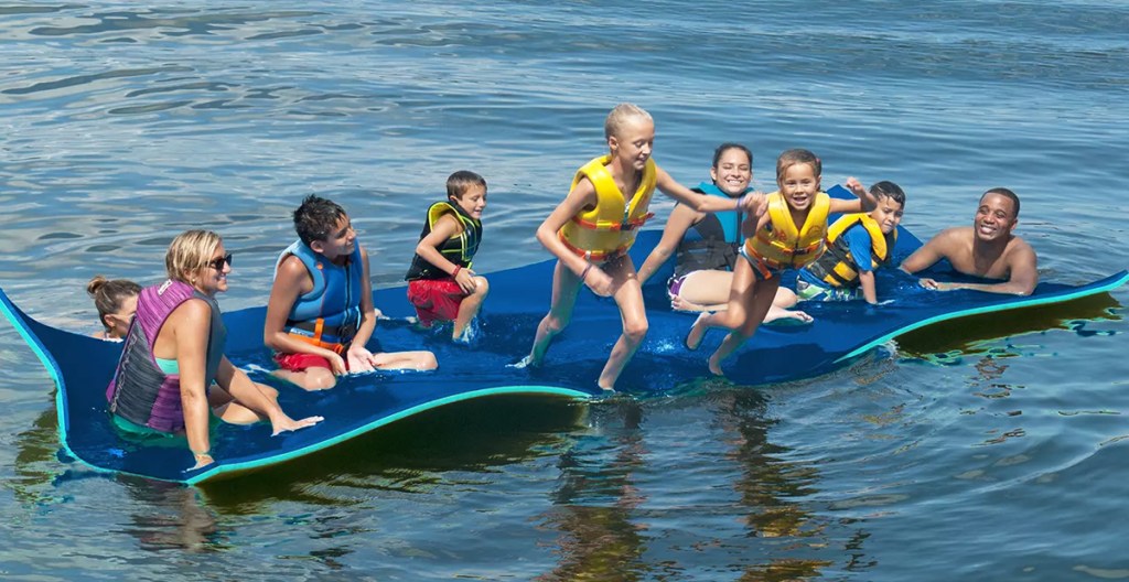 family on a large floating water pad in lake