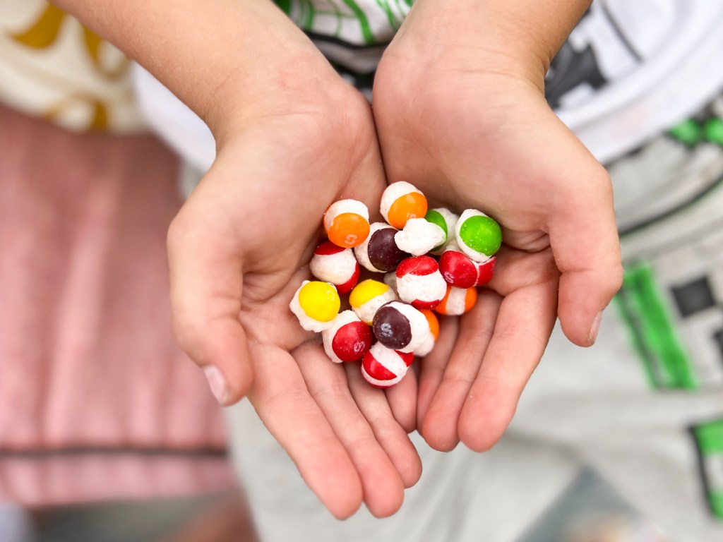 hand holding freeze dried skittles