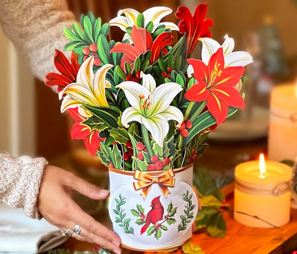 woman holding a paper bouquet of red and white lilies