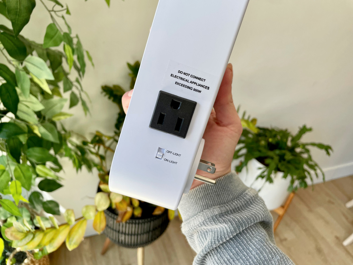 Woman holding up her Hunter Plug-In Air Sanitizer that she bought from QVC