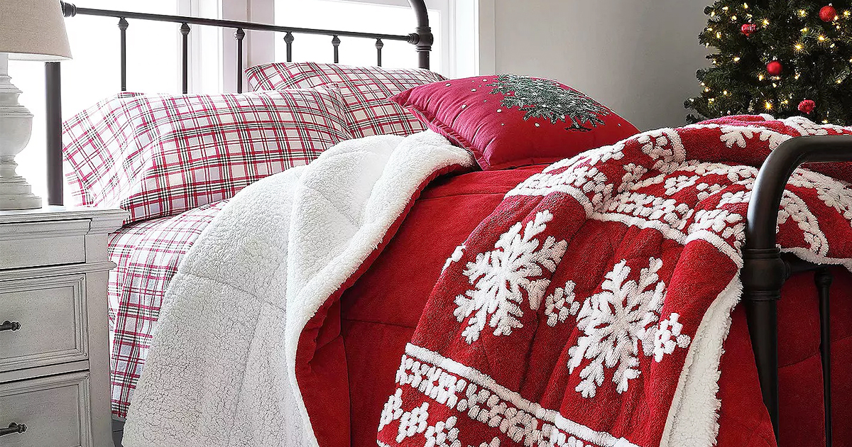 bed with plaid sheets, red onlineforter, and red and white snowflake print throw