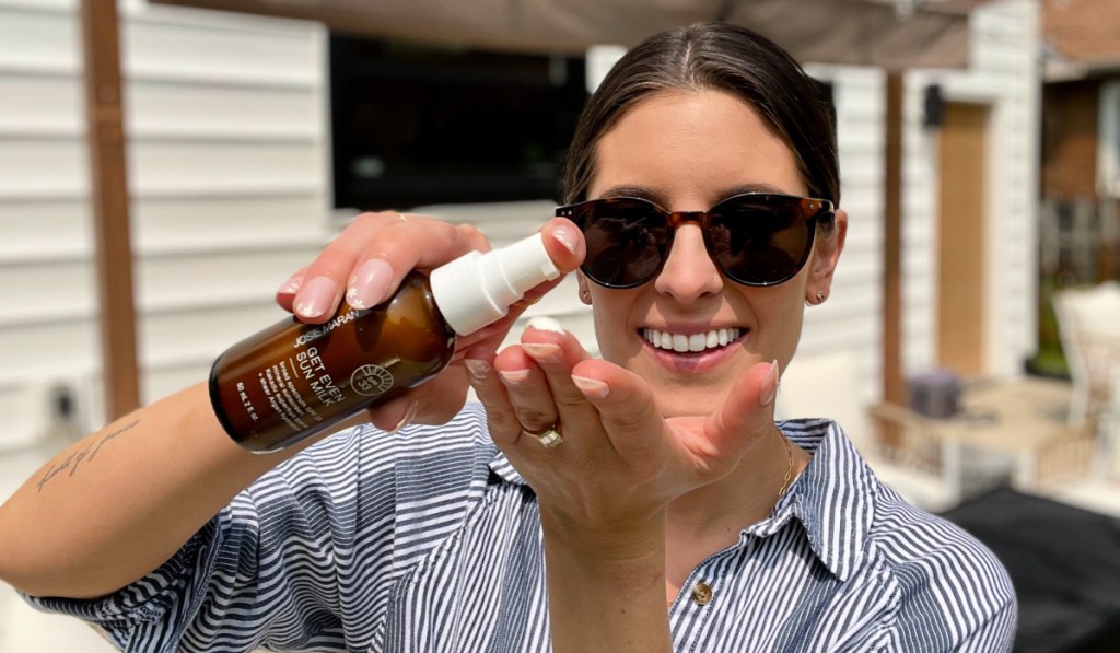 Woman pumping Josie Maran Sun Milk sunscreen into her hand