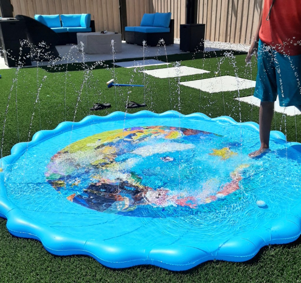 round blue splash pad on grass in backyard