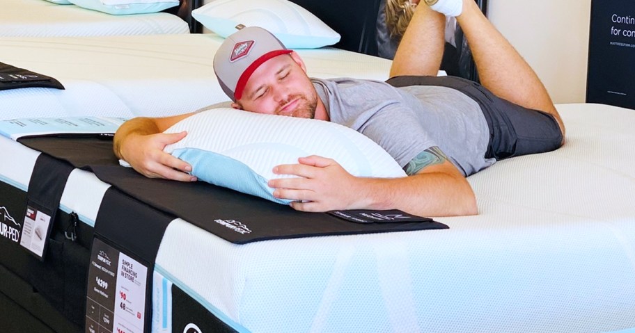 man laying on a mattress with a pillow