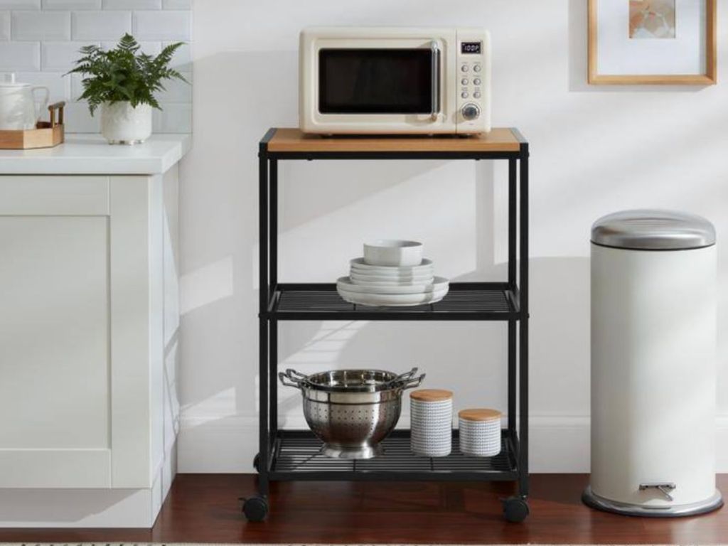 a black metal microwave stand with microwave on it 