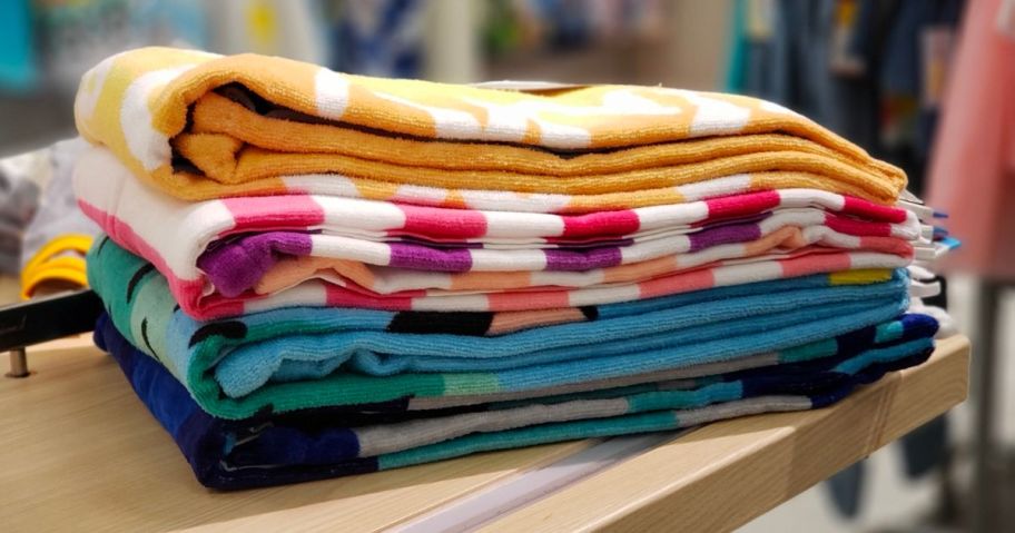 Sun Squad beach towels folded and stacked on a shelf at target