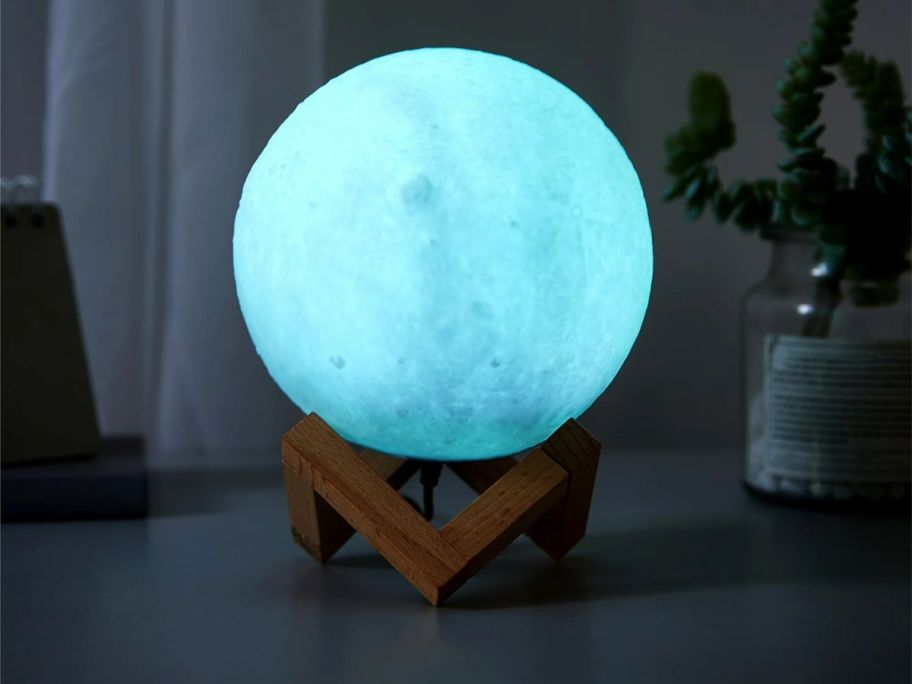 a glowing 3d moon globe light on a table top