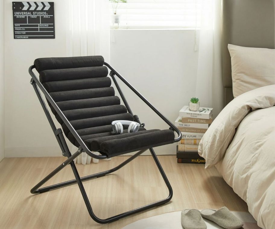 a black faux suede sling chair in a bedroom