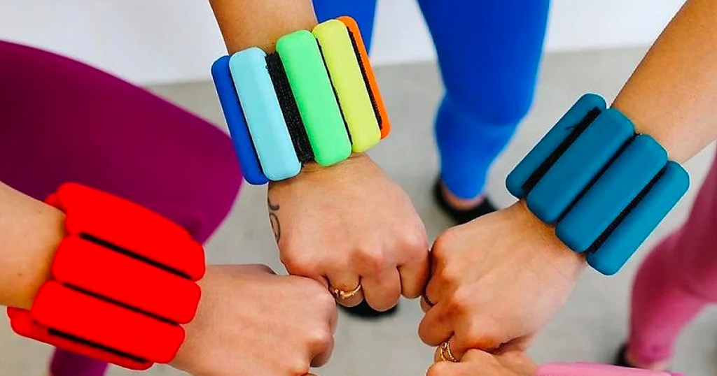 three hands with multi-colored bangles on wrist