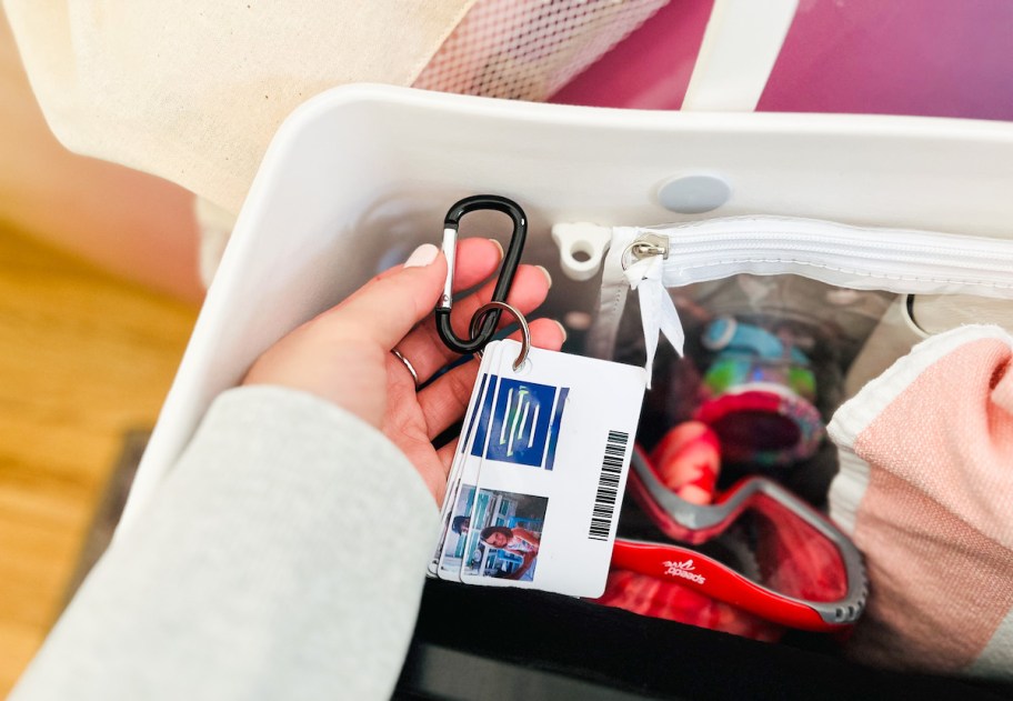 hand holding carabiner with pool passes