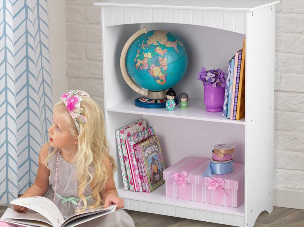 girl reading with bookshelf in background