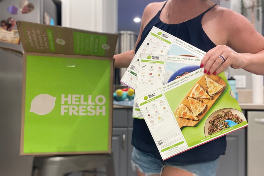 woman holding hello fresh box and recipe cards