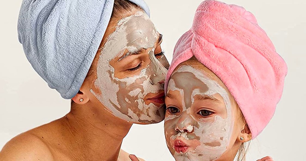 mom and child wearing blue and pink hair towels with face masks on