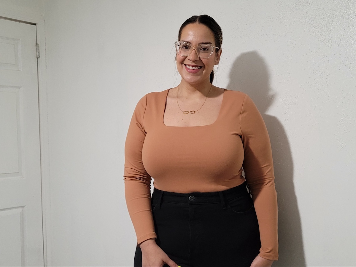 woman posing in orange square neck bodysuit wearing glasses