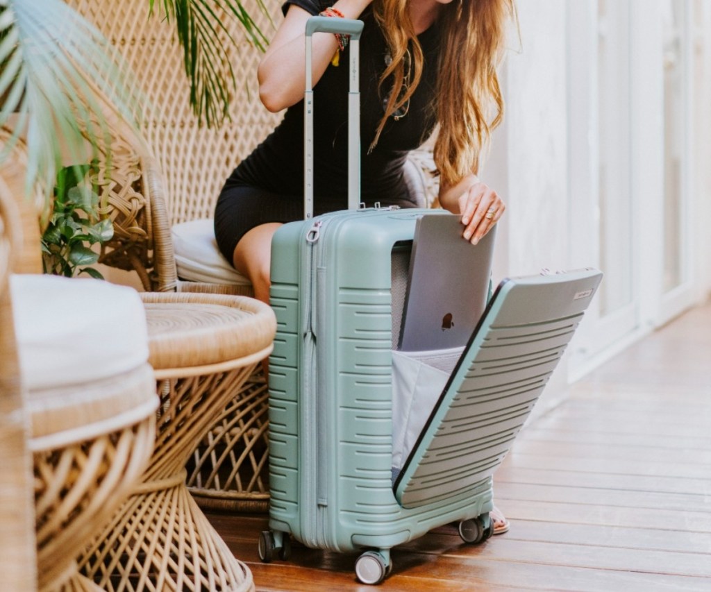 woman pulling MacBook from luggage