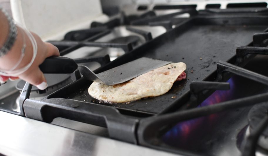 smashing a tortilla on top of a burger