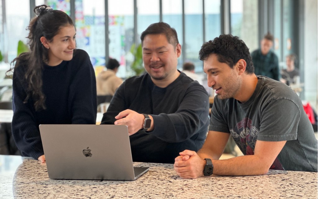 people sitting around looking at laptop screen