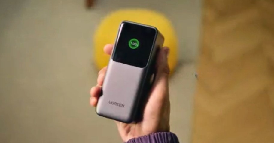 a hand holding a silver and black UGREEN large power bank