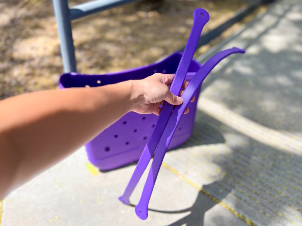 hands holding straps to beach bag not placed on yet