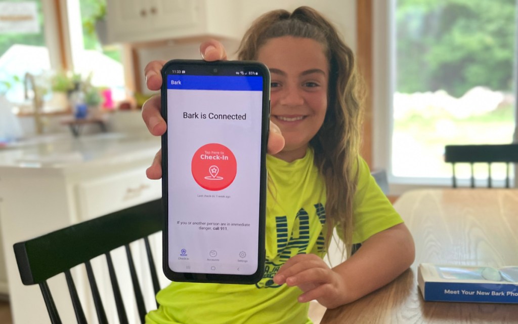 Girl holding up a Bark Phone for kids