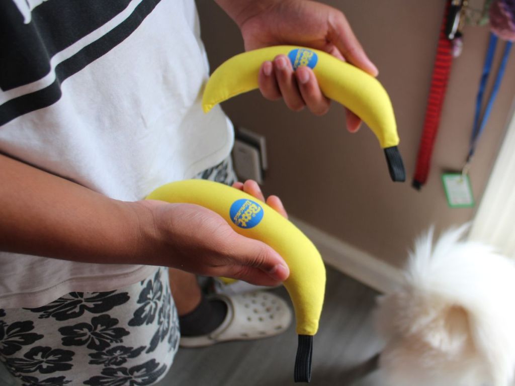 Teen boy holding two Boot Bananas