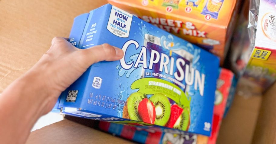 person pulling out box of Caprisun juices from Amazon subscribe & save order