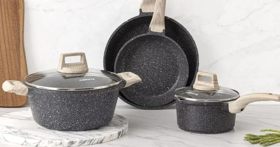 Grey cookware set with lids on a counter