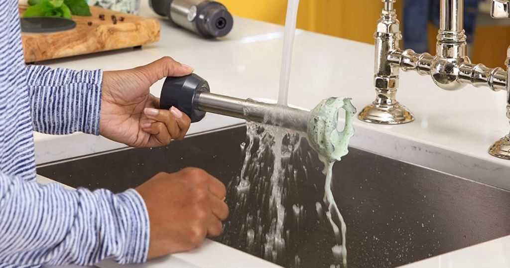 a woman cleaning the wand from a GE immersion blender 2