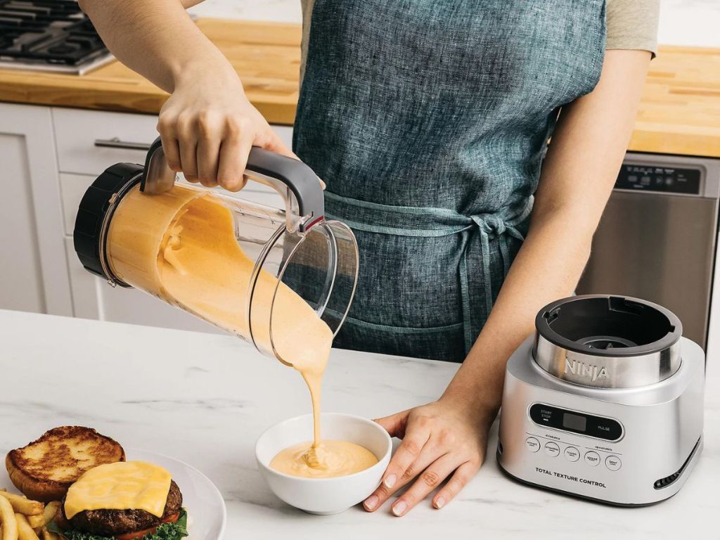 person puring puree from blender into dip bowl