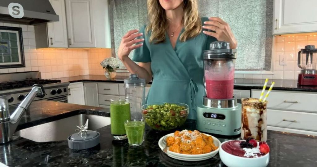 mint green blender with pink smoothie in pitcher and glasses of green smoothies surrounding it