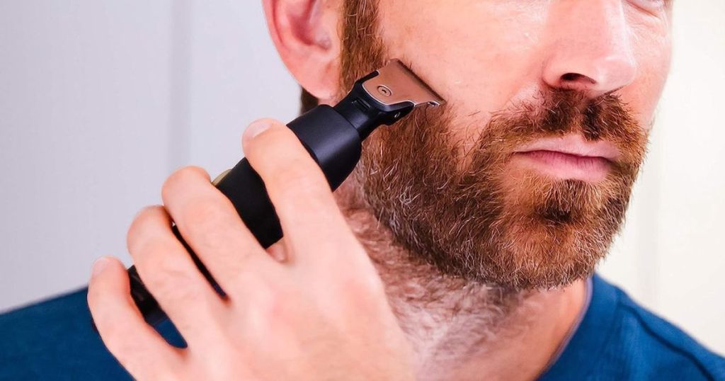 man using trimmer on beard