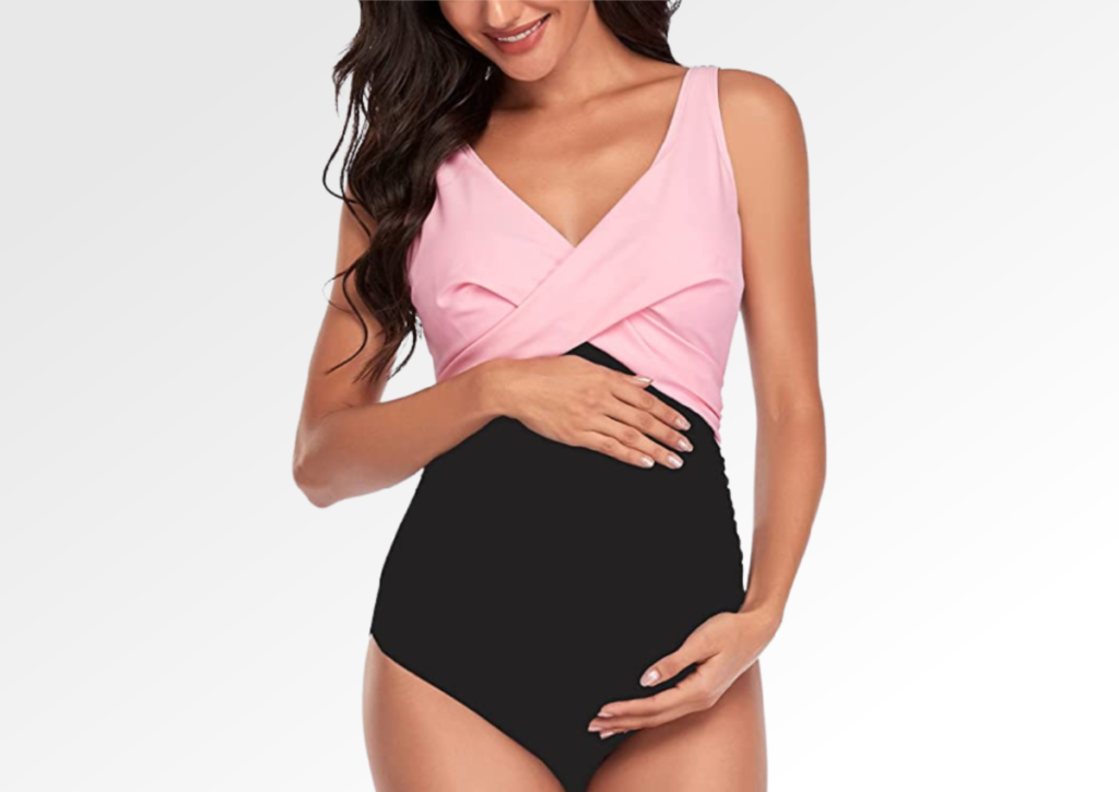 Woman modeling a pink and black maternity swimsuit from Amazon