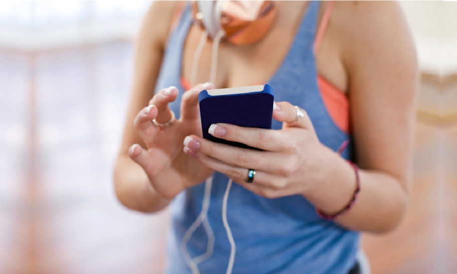 woman in workout clothes holding phone