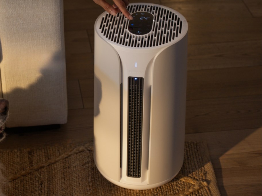 a tan color air purifier, fan, and heater 3 in 1 machine in a living room