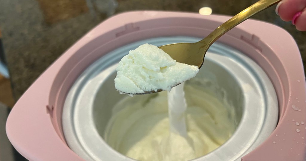 pink cook essentials ice cream maker with spoon taking ice cream out