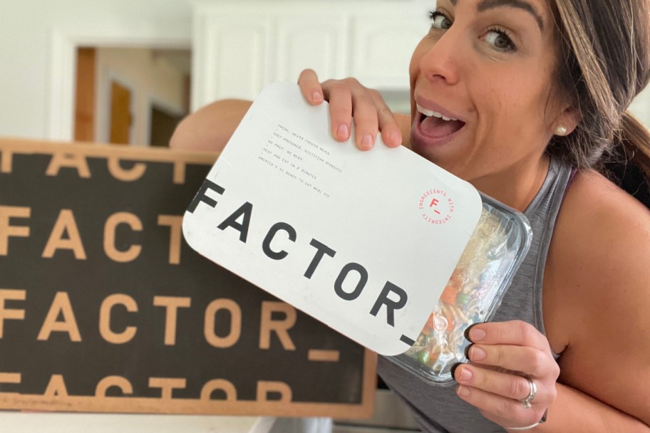 woman holding factor prepared meal in hand