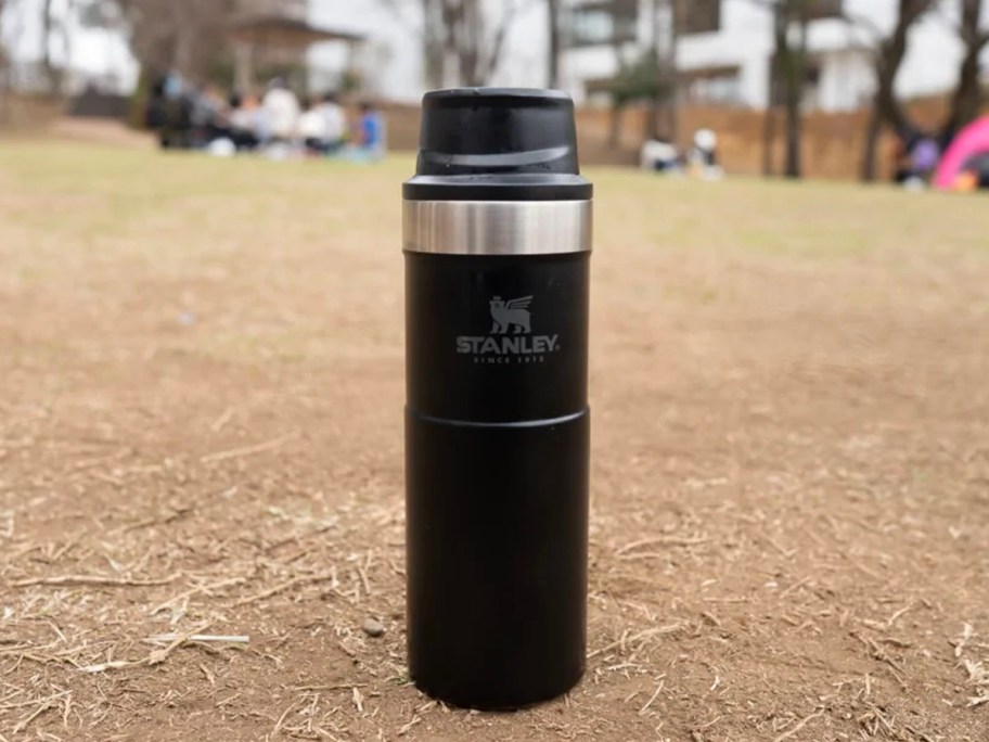 black stanley trigger action tumbler sitting on ground