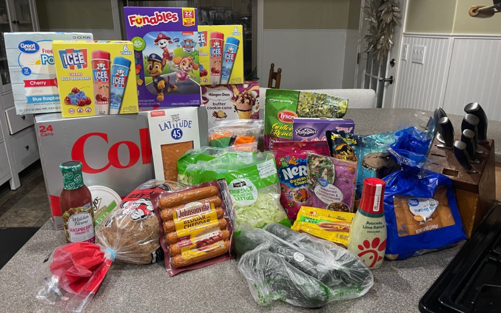 a collection of groceries in walmart delivery bags on a countertop