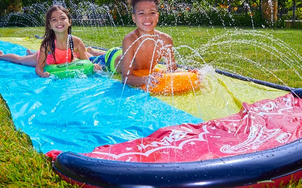 two kids playing on wham o slip n slide