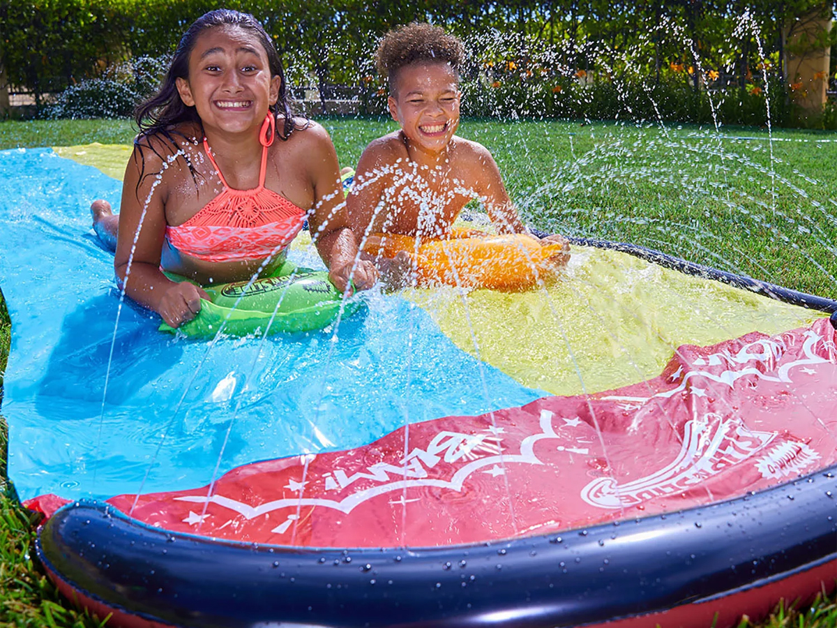 two kids playing on wham o slip n slide