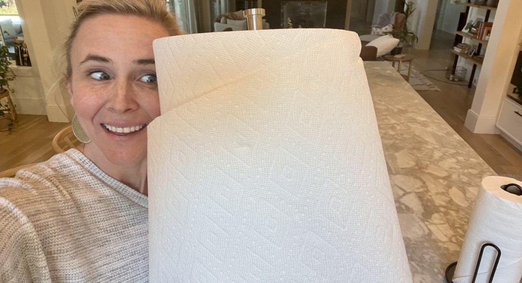 woman holding HUGE bounty roll of paper next to her head