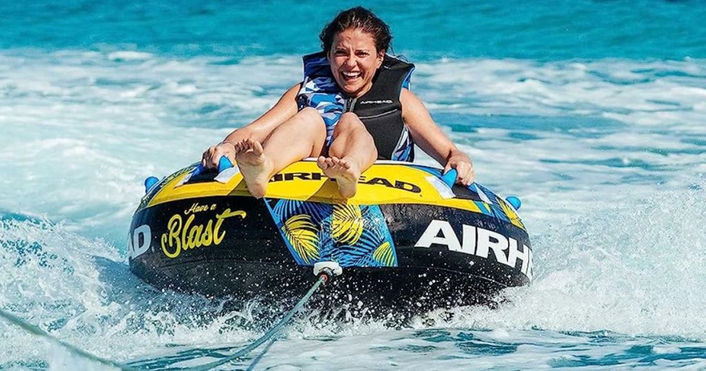 Boy riding a AIRHEAD Blast Towable Tube for Boating with 1-4 Rider Options in the water